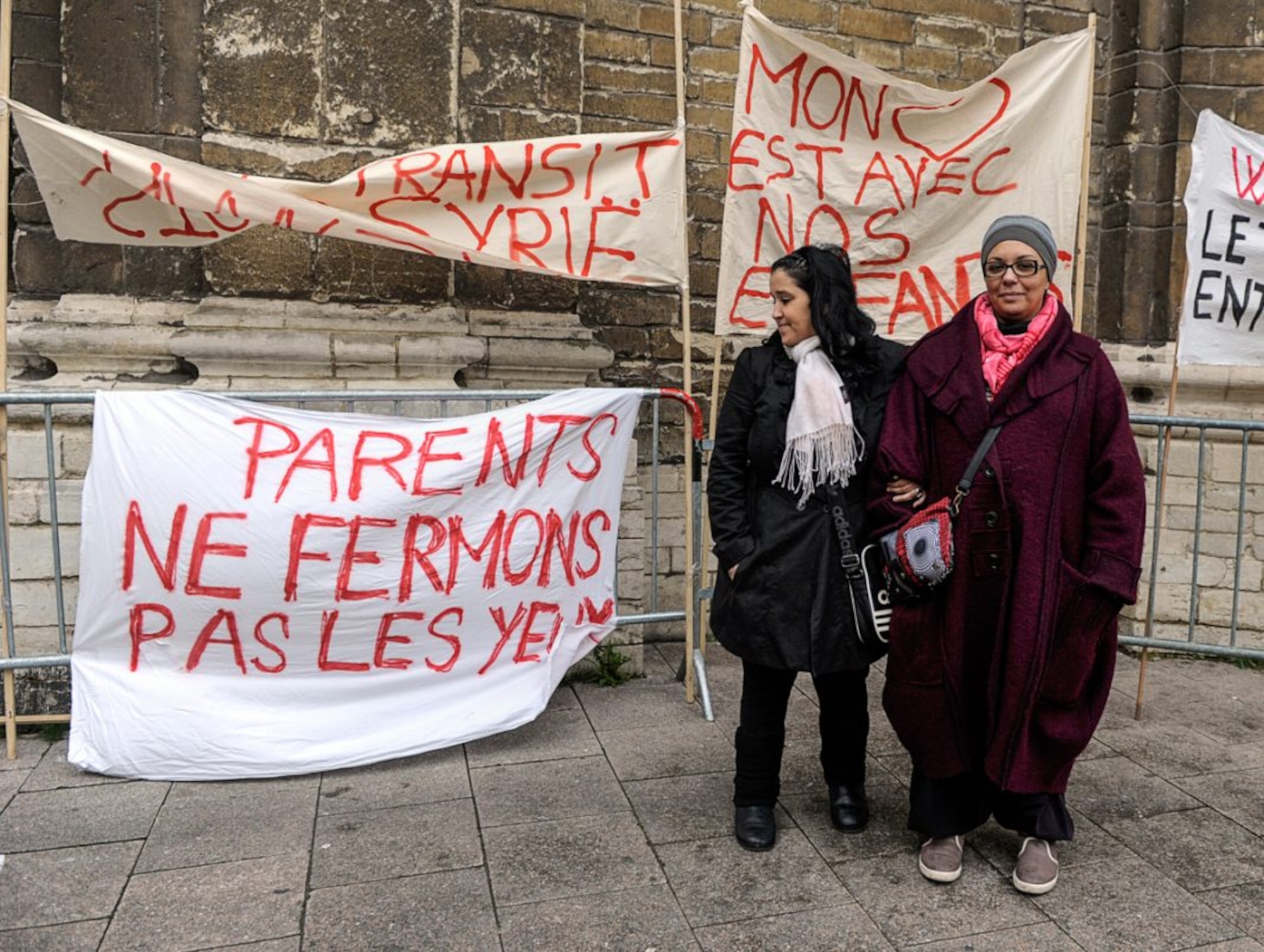 Saliha Ben Ali (right) joins another mother to protest against Belgian youths fighting in Syria. The lower left banner reads: "Parents: let us not close our eyes." (© Laurent Dubrule /Reuters)