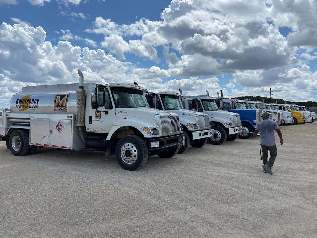 a line of fuel trucks parked with a man walking in front