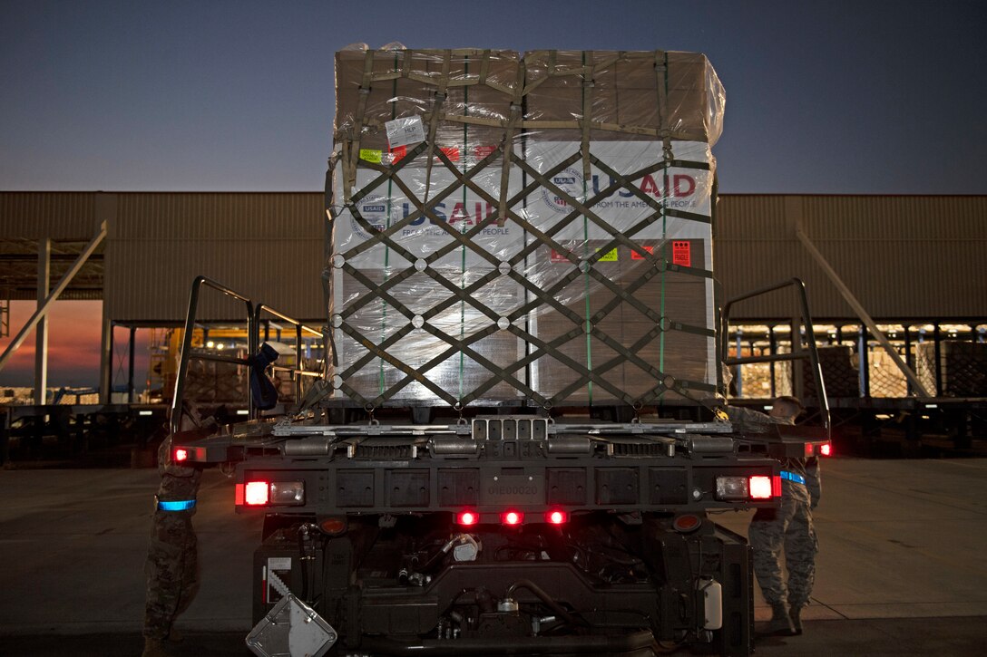 photos of aerial port airmen loading USAID of ventilators into a c-17 globemaster III.