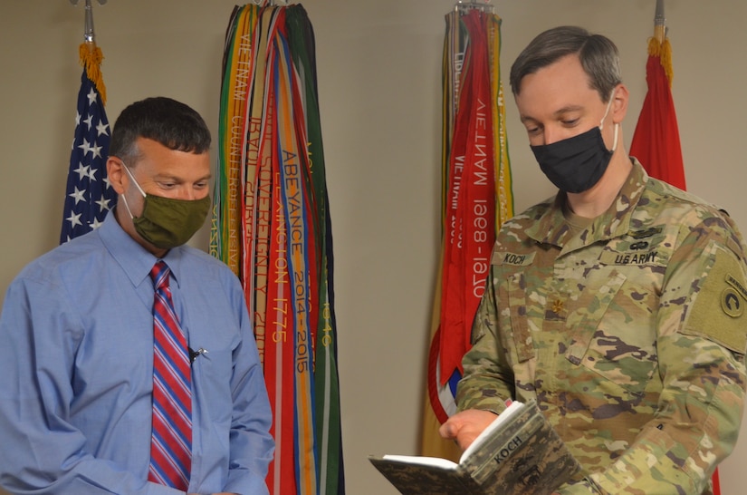 David C. Dusterhoff, deputy chief of staff, 1st Theater Sustainment Command, reviews upcoming tasks with Maj. Owen Koch, force management officer, at Fort Knox, Kentucky, Aug. 19, 2020. With more than 30 years of total federal service to draw upon, Dusterhoff uses this experience to manage daily operations within the 1st TSC. (U.S. Army Photo by Sgt. 1st Class Noel Gerig, 1st TSC Public Affairs)