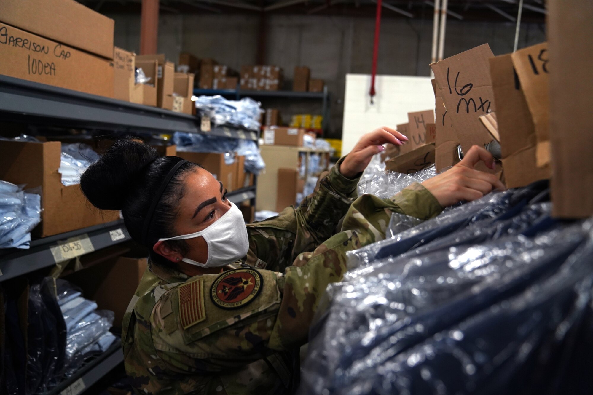 U.S. Air Force Master Sgt. Melina Jimerson, 81st Logistics Readiness Squadron basic military training supply lead, helps a 737th Training Wing Detachment 5 basic military training trainee fill out a clothing issue form inside the 81st LRS warehouse at Keesler Air Force Base, Mississippi, Aug. 26, 2020. The 81st LRS worked with different Air Education and Training Command units to support BMT at Keesler by providing uniforms for trainees. (U.S. Air Force photo by Airman 1st Class Seth Haddix)
