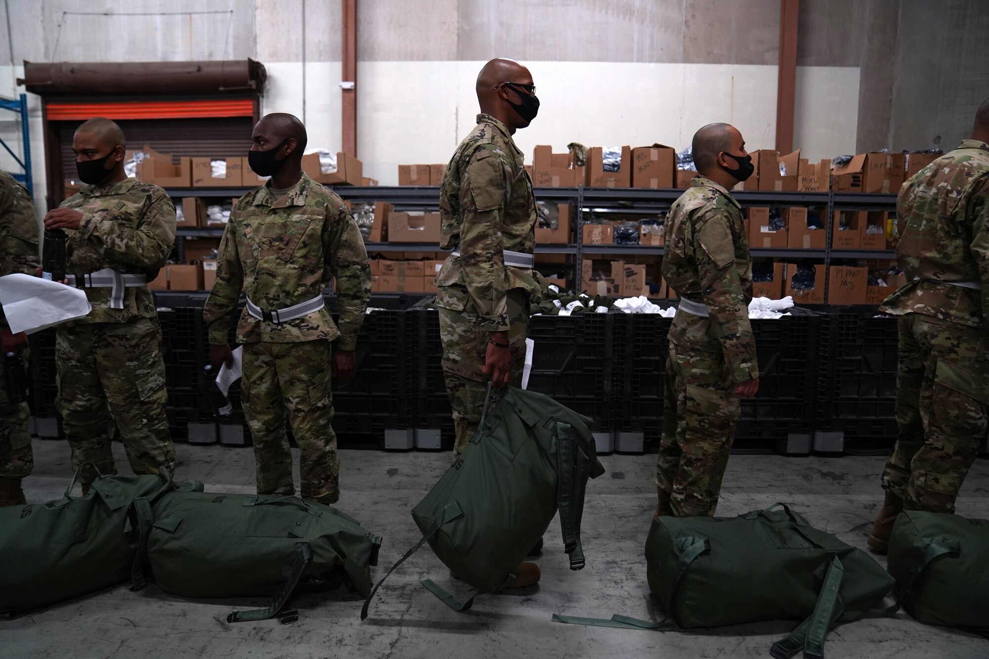 Basic military training trainees from the 737th Training Wing Detachment 5 wait in line to get their issued military clothing inspected inside the 81st Logistics Readiness Squadron warehouse at Keesler Air Force Base, Mississippi, Aug. 26, 2020. The 81st LRS worked with different Air Education and Training Command units to support BMT at Keesler by providing uniforms for trainees. (U.S. Air Force photo by Airman 1st Class Seth Haddix)