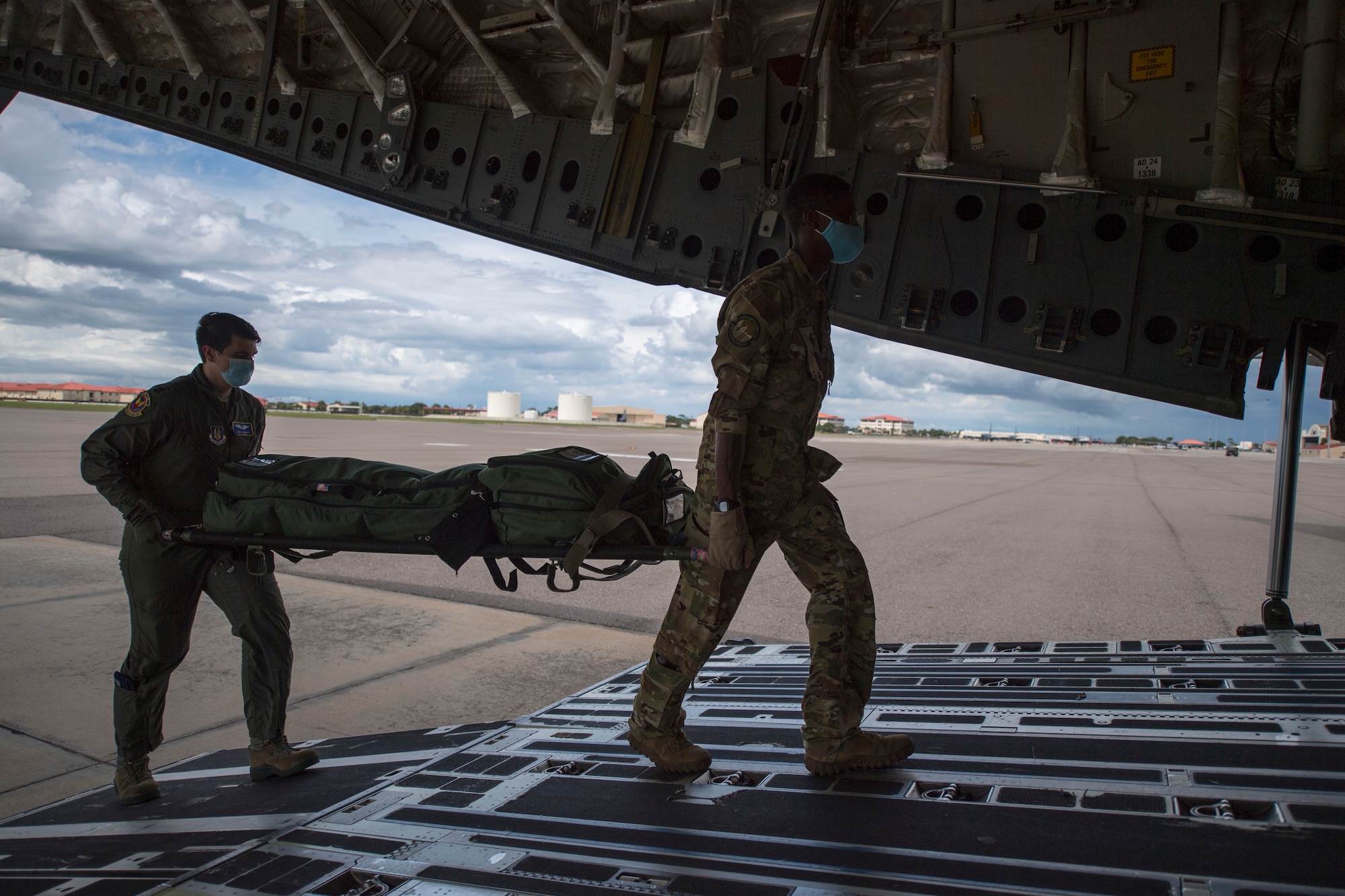 Members of the 908th Aeromedical Evacuation Squadron (AES), Maxwell AFB, Ala., and the 45th AES, carry a litter of medical supplies onboard a C-17 Globemaster III aircraft assigned to the 512th Airlift Wing, Dover AFB, at MacDill Air Force Base, Fla., Aug. 21, 2020.