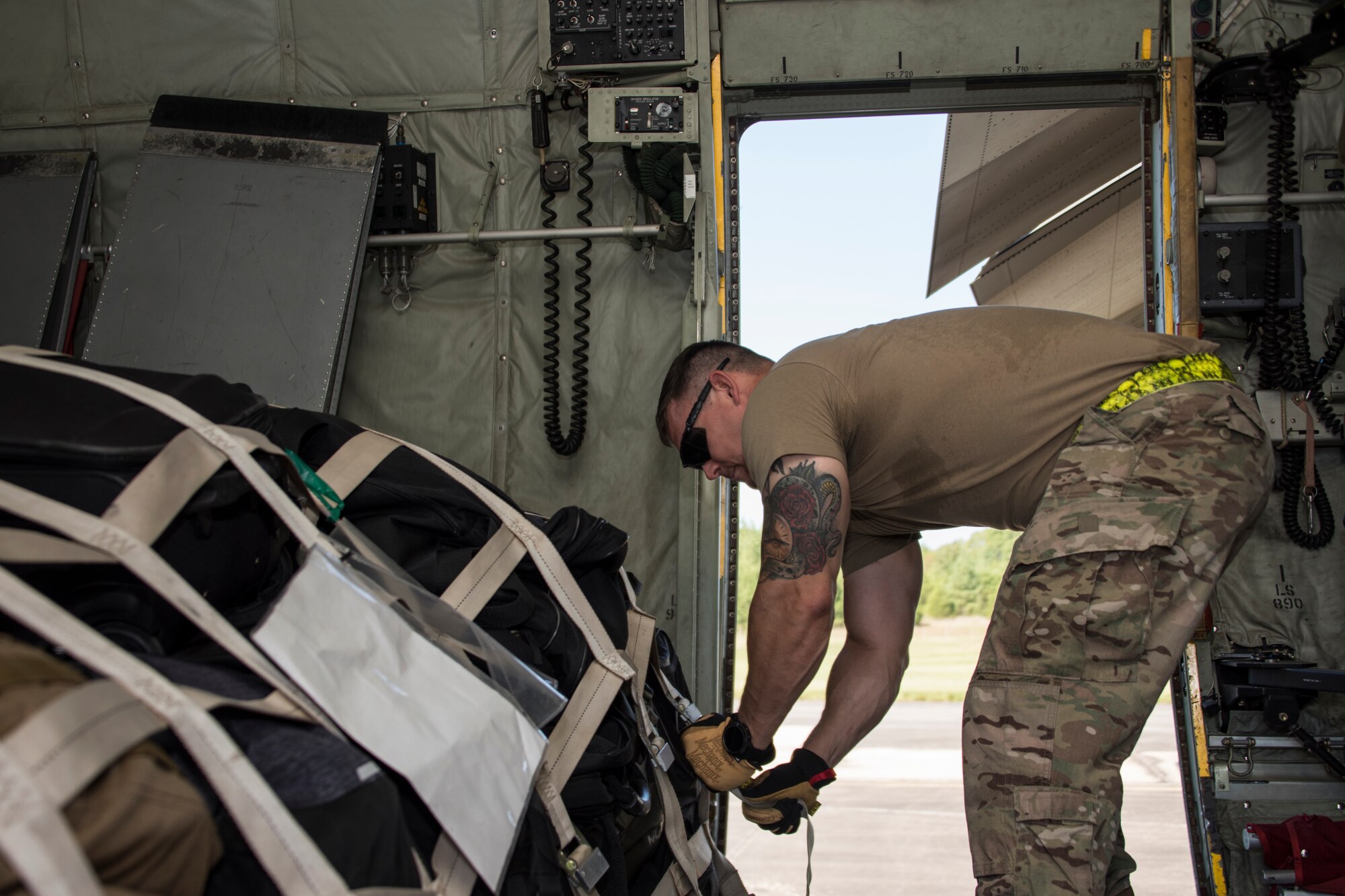 A photo of an Airman strapping down cargo