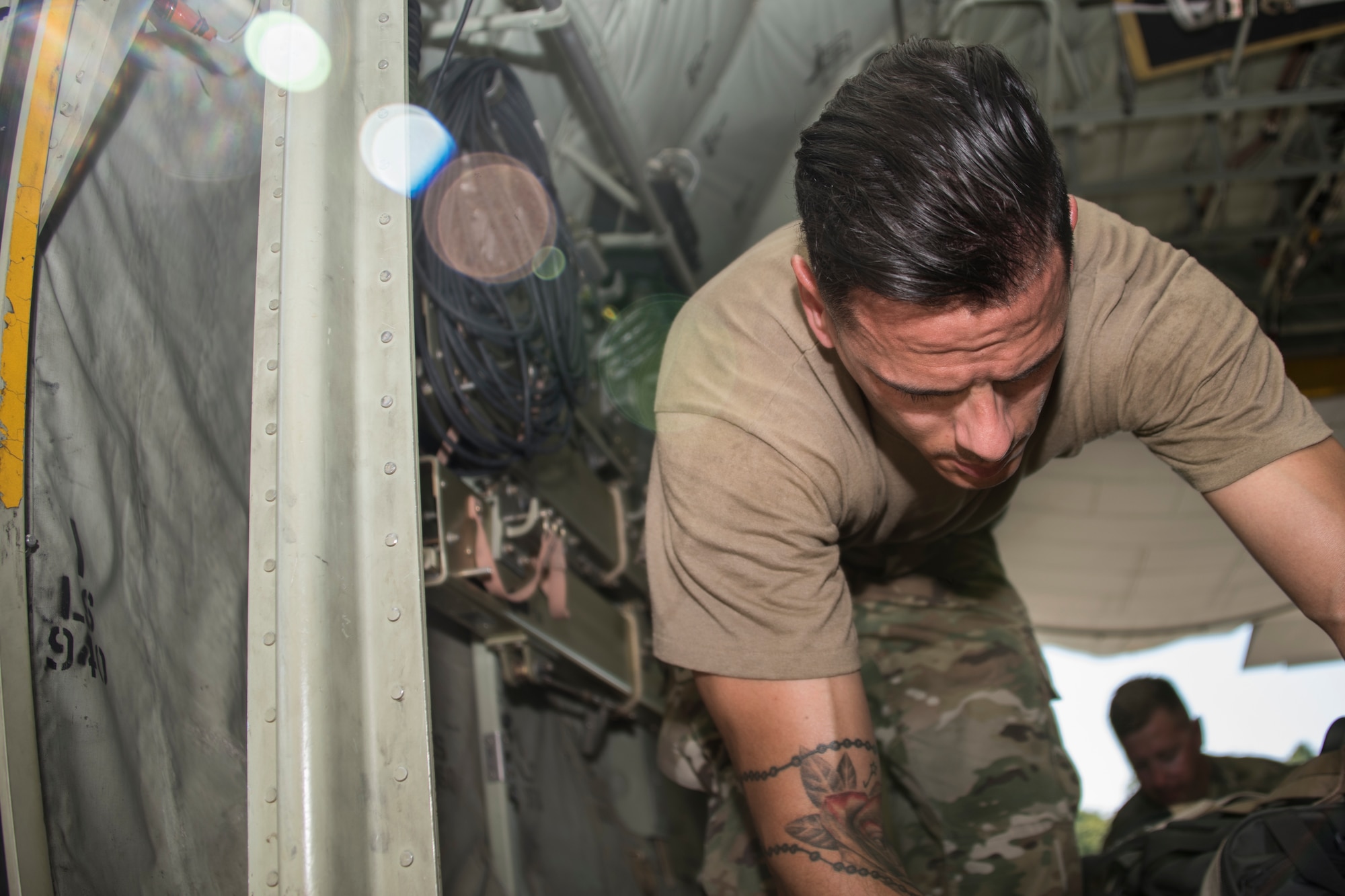 A photo of an Airman strapping down cargo