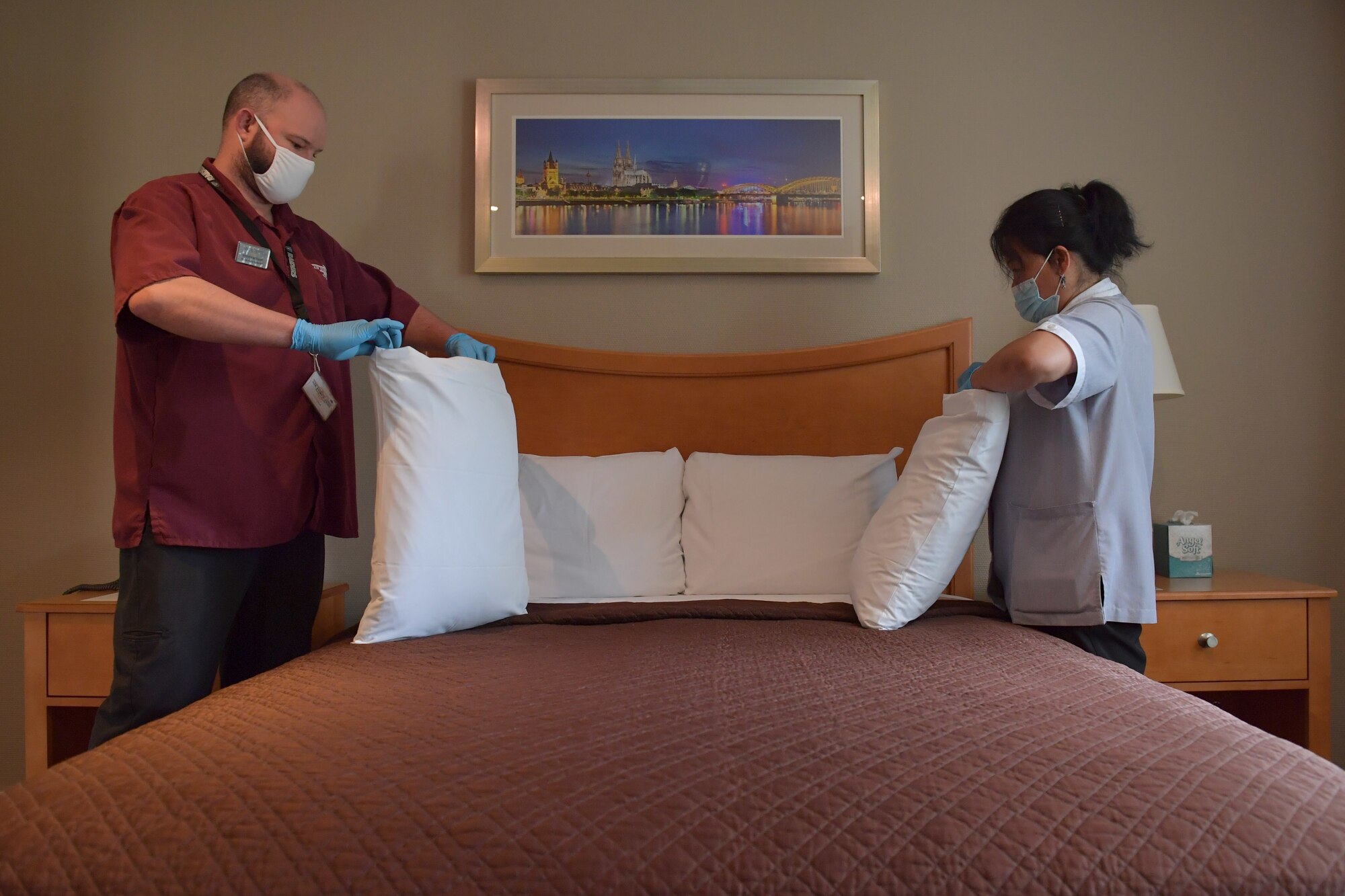 Two people changing pillow cases.