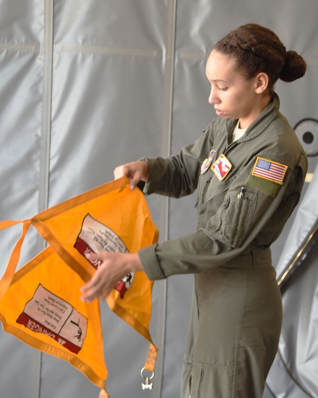 Senior Airman Madison Doherty, 924th Air Refueling Squadron boom operator and load master, unfolds a cargo hold barrier on the front load door of a KC-46A Pegasus assigned the 22nd Air Refueling Wing Aug. 20, 2020, at Andersen Air Base, Guam. Doherty was part of the first 931st Air Refueling Wing-lead KC-46 cargo load mission that stopped at four locations in six days, and loaded more than 11,000 pounds of pallets worldwide.