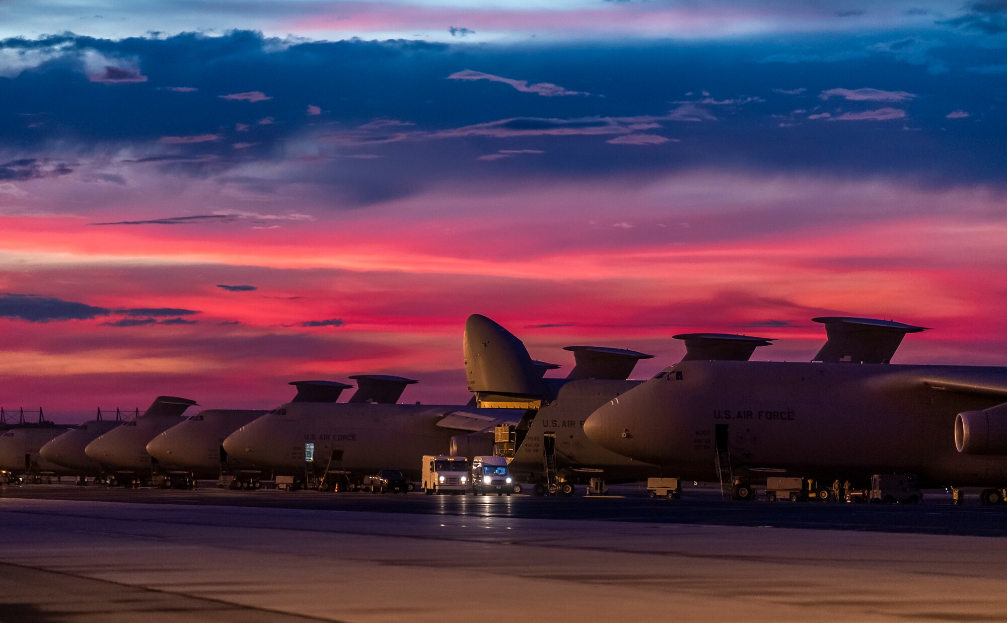 The sun sets over Dover Air Force Base, Delaware, as Airmen work on the flight line Aug. 12, 2020.  The 436th Airlift Wing generates global strategic airlift with both C-5M Super Galaxy and C-17A Globemaster III.  (U.S. Air Force photo by Senior Airman Christopher Quail)