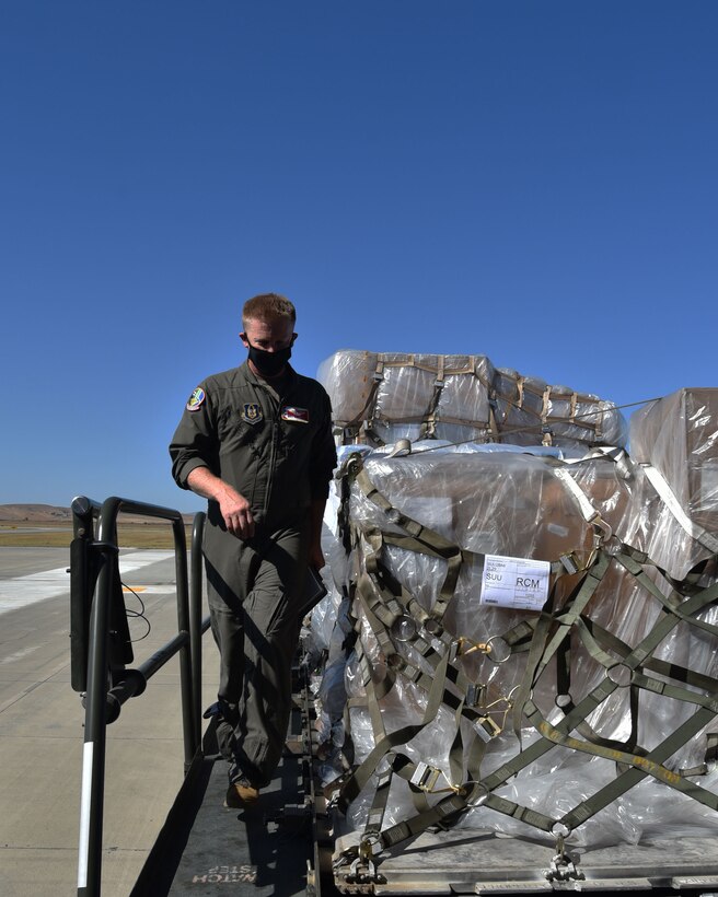 Senior Master Sgt. Bryan Fehrenbach (left) and Senior Airman Madison Doherty (right), 924th Air Refueling Squadron boom operators and load masters, haul a cargo pallet onto a KC-46A Pegasus assigned to McConnell Air Force Base, Kansas, Aug. 15, 2020, at Travis Air Force Base, California. This was the first Reserve-lead cargo load utilizing the KC-46.