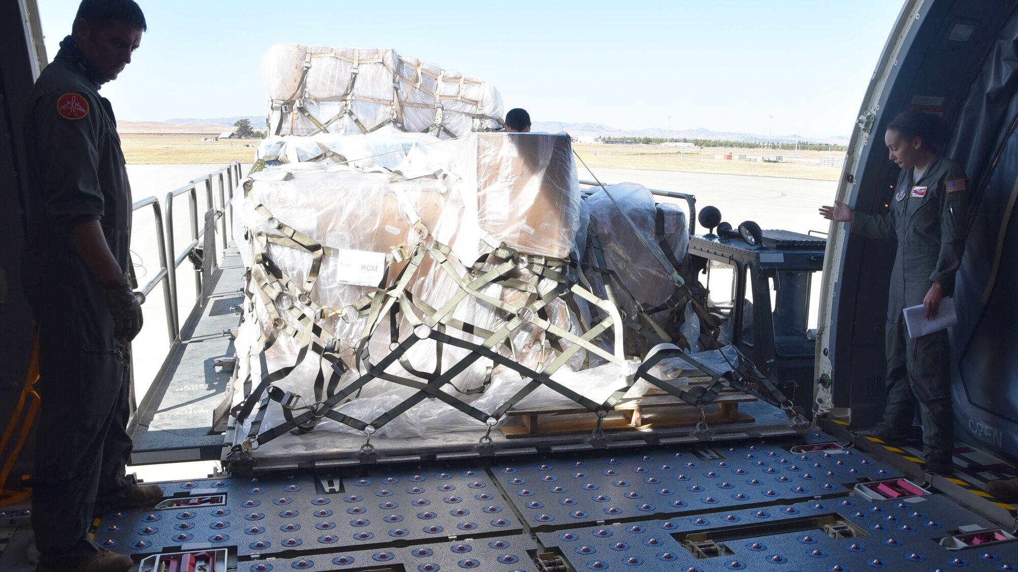 Master Sgt. Bryan Fehrenbach (left) and Senior Airman Madison Doherty (right), 924th Air Refueling Squadron boom operators and load masters, haul a cargo pallet onto a KC-46A Pegasus assigned to McConnell Air Force Base, Kansas, Aug. 15, 2020, at Travis Air Force Base, California. This was the first Reserve-lead cargo load utilizing the KC-46.