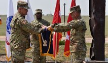 Gen. James H. Dickinson, U.S. Space Command commander, left, and Lt. Gen. Daniel L. Karbler, U.S. Army Space and Missile Defense Command commanding general, unfurl SMDC's colors to officially recognize the command as the Army Service Component Command to USSPACECOM during a ceremony at Schriever Air Force Base, Colorado, Aug. 21. (U.S. Army photo by Dottie K. White)