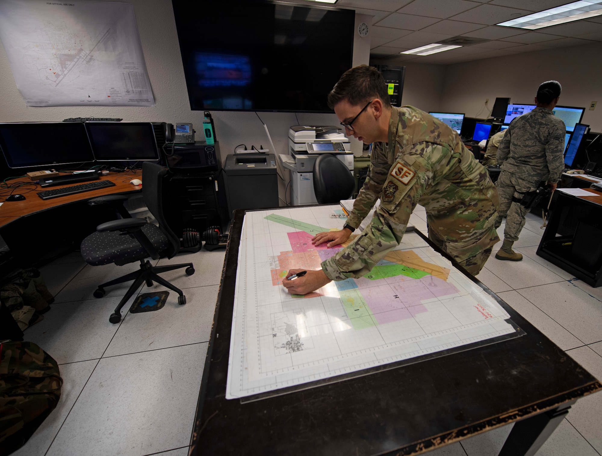 U.S. Air Force Staff Sgt. Michael Itami, 60th Security Forces Squadron emergency communications center controller, describes base evacuation procedures Aug. 24, 2020, at Travis Air Force Base, California. The SFS was notified Aug. 19 to evacuate more than 8,000 base personnel due to the wildfires that have burned more than 1.5 million acres in the surrounding area. (U.S. Air Force photo by Senior Airman Jonathon Carnell)