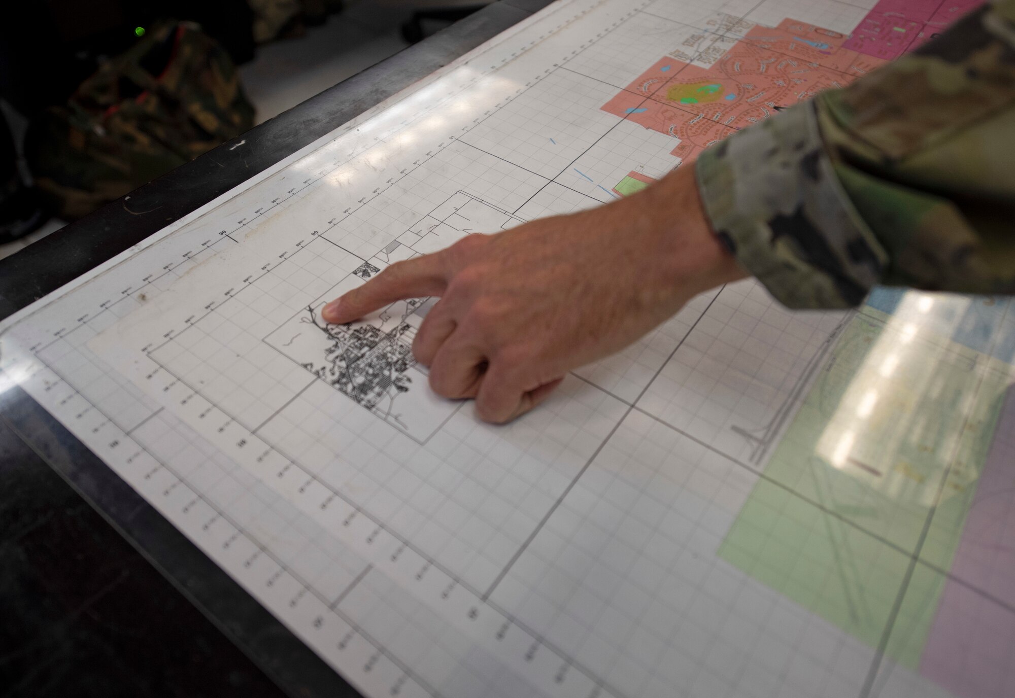 U.S. Air Force Staff Sgt. Michael Itami, 60th Security Forces Squadron emergency communications center controller, points at a map of the base Aug. 24, 2020, at Travis Air Force Base, California. The SFS was notified Aug. 19 to evacuate more than 8,000 base personnel due to the wildfires that have burned more than 1.5 million acres in the surrounding area. (U.S. Air Force photo by Senior Airman Jonathon Carnell)