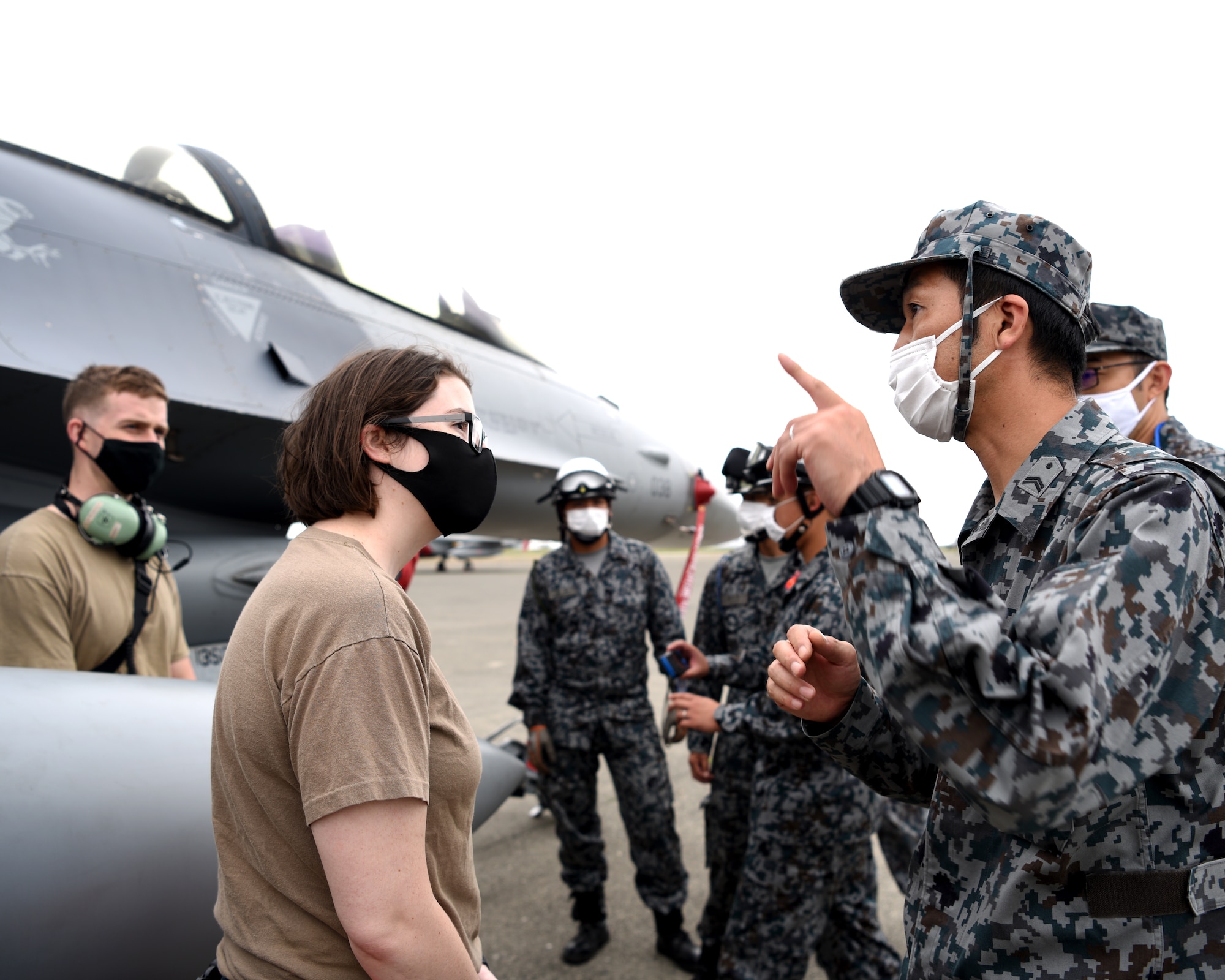 U.S. Air Force Tech. Sgt. Bailey Delaney, 13th Aircraft Maintenance Squadron debrief NCO-in charge, explains F-16 operations to Koku-Jieitai personnel during Aviation Training Relocation at Chitose Air Base, Japan Aug. 25, 2020.