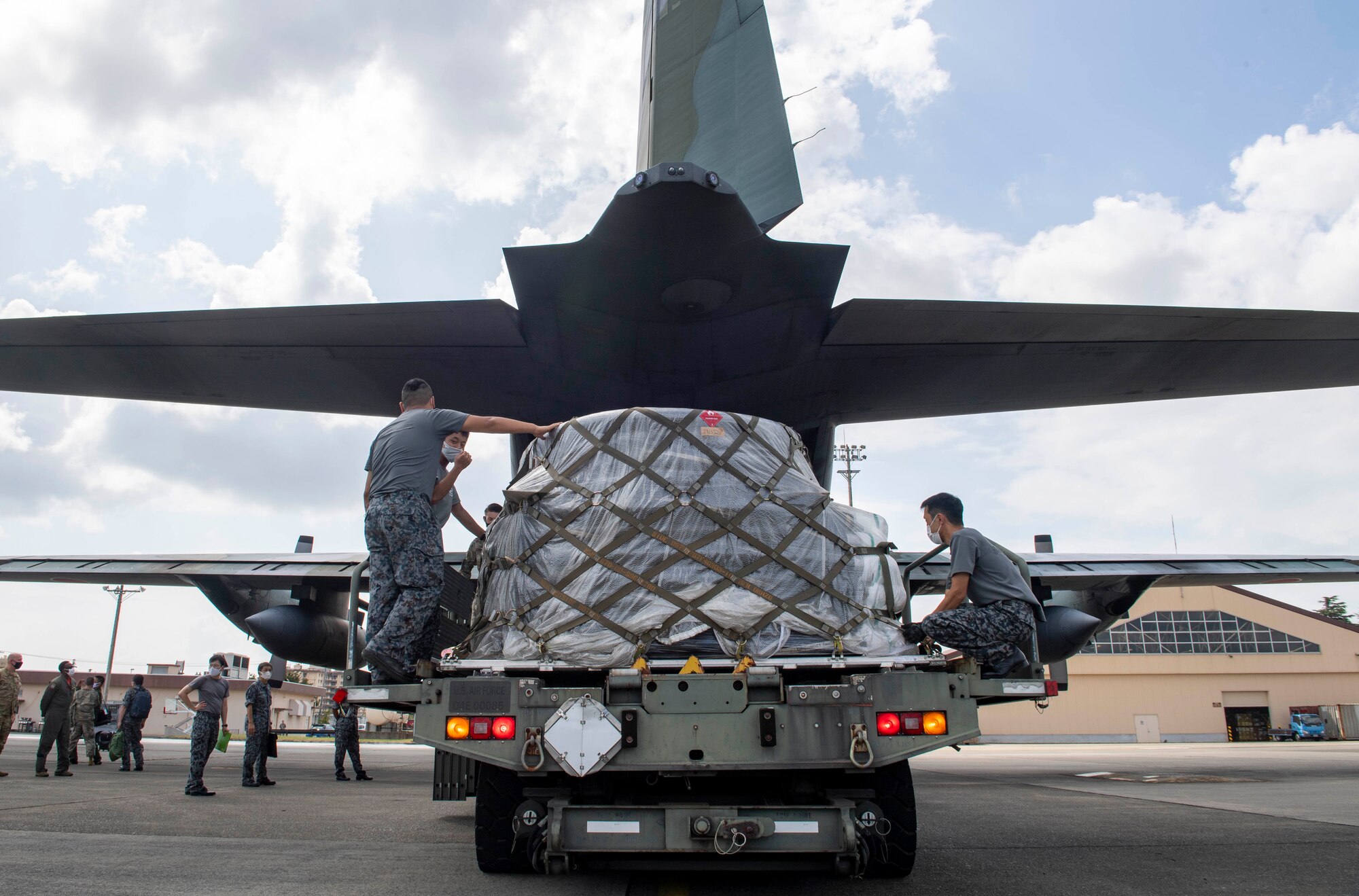 Japanese Air Self Defense Force Airmen load cargo on to a JASDF C-130H Hercules during bilateral cargo exchange training at Yokota Air Base, Japan, Aug. 28, 2020.