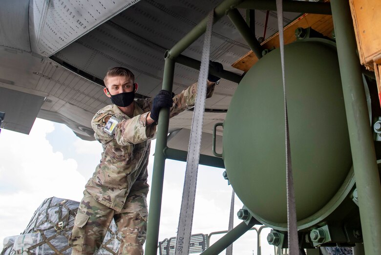 Senior Airman Marcus Johnson, 374th Logistics Readiness Squadron combat mobility operations technician, loads cargo into a Japanese Self Defense Force C-130H Hercules during bilateral cargo exchange training at Yokota Air Base, Japan, Aug. 28, 2020.