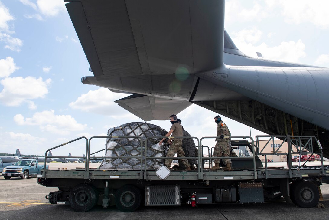 Airmen assigned to the 374th Logistics Readiness Squadron, load cargo onto a K Loader from a C-130J Super Hercules, assigned to the 36th Airlift Squadron, during bilateral exchange training, at Yokota Air Base, Japan, Aug. 28, 2020.