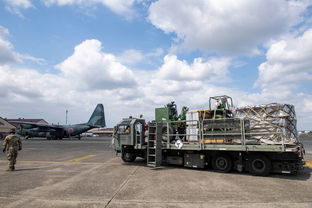 Airmen from the 374th Logistics Readiness Squadron transport cargo belonging to the Japanese Air Self Defense Force from a C-130J Super Hercules, assigned to the 36th Airlift Squadron, to a JASDF C-130H Hercules during bilateral exchange training at Yokota Air Base, Japan, Aug. 28, 2020.