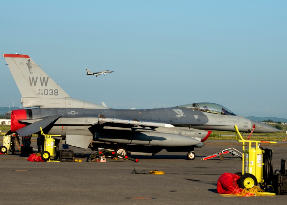 An F-15C Eagle begins its descent, seen above an F-16C Fighting Falcon during an Aviation Training Relocation event at Chitose Air Base, Japan Aug. 27, 2020.