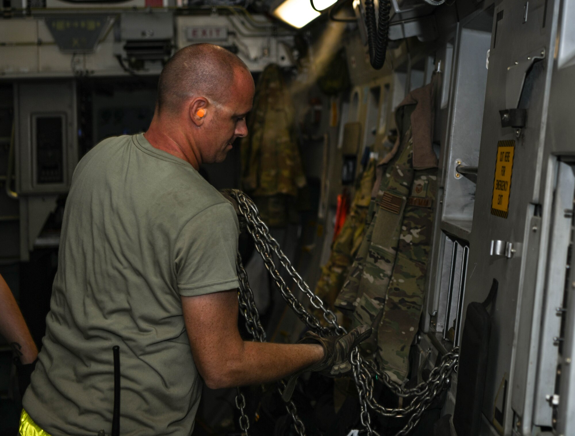 Tech. Sgt. Ryan Gilroy, 380th Expeditionary Logistics Readiness Squadron cargo noncommissioned officer in charge, connects a chain to the wall of a C-17 Globemaster III aircraft, August 26, 2020, at Al Dhafra Air Base, United Arab Emirates.