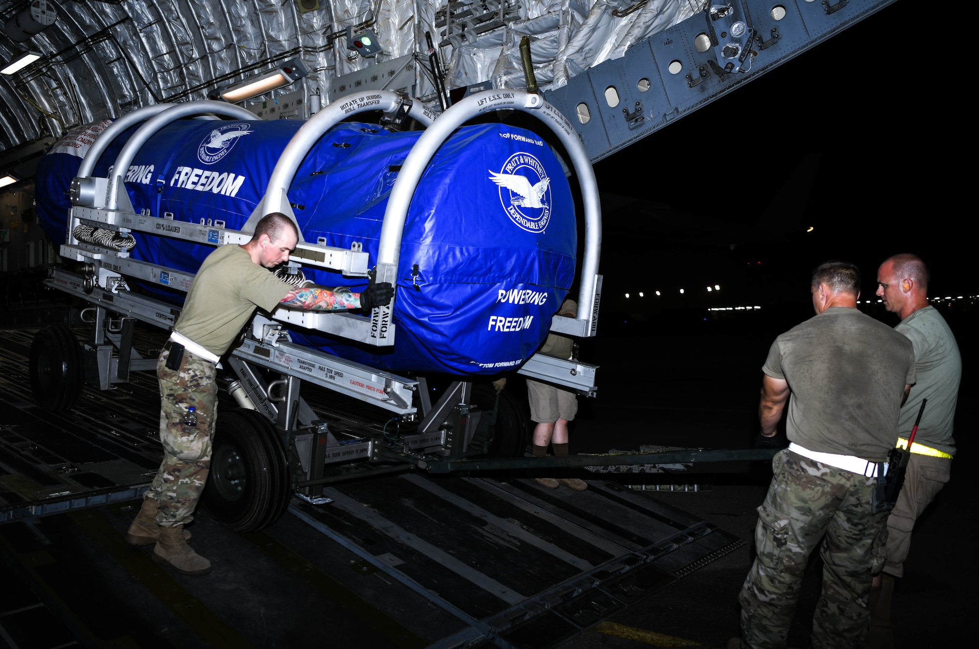 Members of the 380th Expeditionary Logistics Readiness Squadron Air Terminal Operations Center wheel an F-35A Lightning II engine out of a C-17 Globemaster III aircraft, August 26, 2020, at Al Dhafra Air Base, United Arab Emirates.