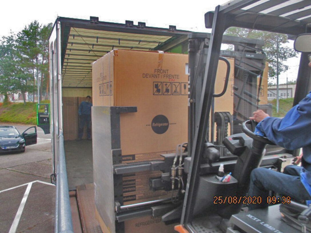 A refrigerator is put into a truck for shipment.