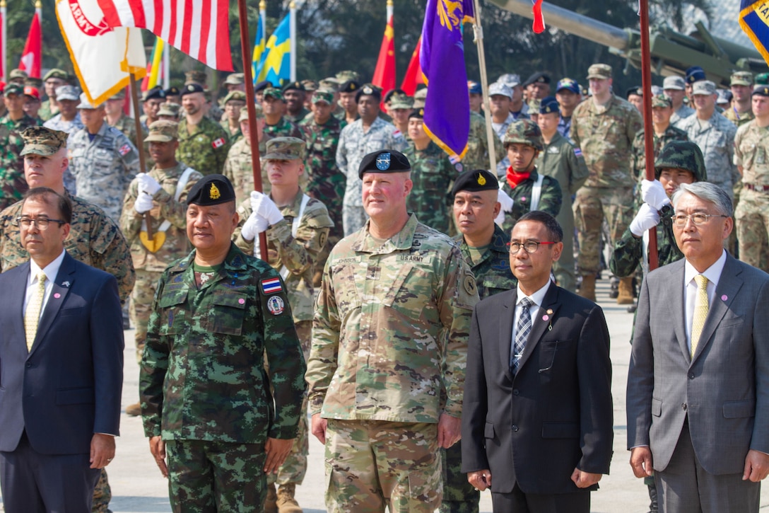 Officers, soldiers and civilian leaders from many different countries stand in formation.