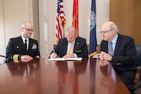 Dr. Andrew T. Phillips (ctr), U.S. Naval Academy academic dean and provost, signs a Memorandum of Agreement with U.S. Naval Research Laboratory commanding officer, Capt. Scott Moran, accompanied by Dr. Gerald Borsuk, associate director of research, NRL Systems Directorate.