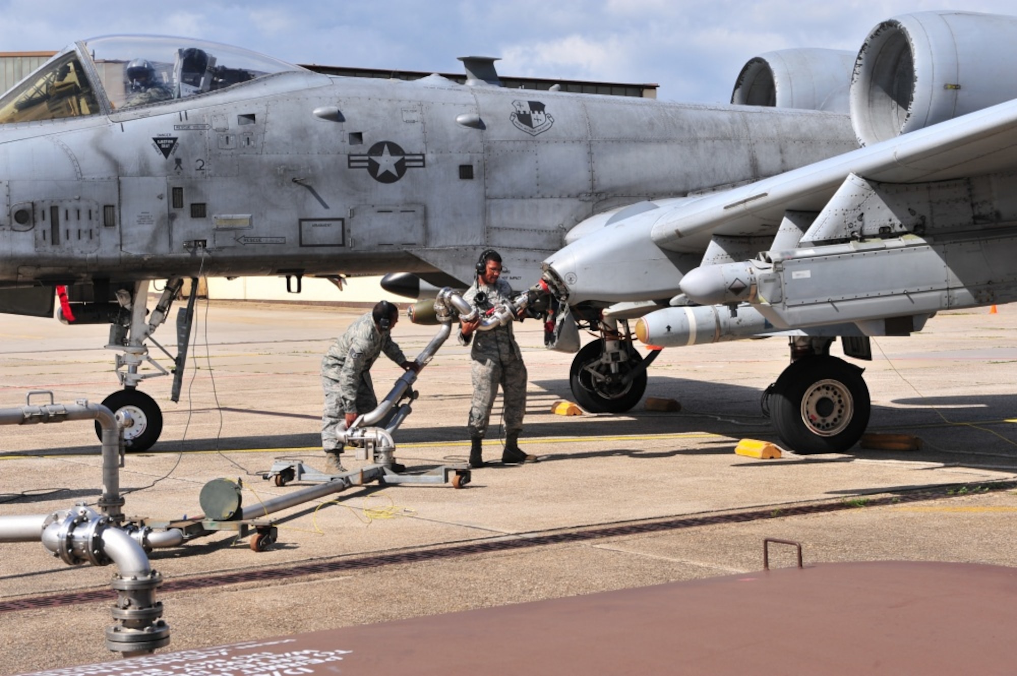 Airmen connect a jet fuel hose to an A-10 Thunderbolt II aircraft during a hot pit refueling at Spangdahlem Air Base, Germany.