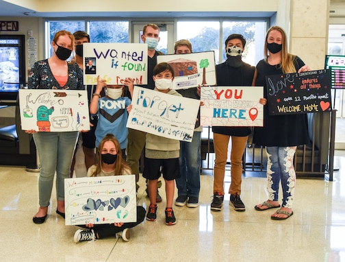 The Neal family welcomes 2nd Lt. Nathan Neal, 315th Training Squadron intelligence instructor, home with signs Aug. 20, 2020 at Mathis Field, San Angelo, Texas. After a challenging one year deployment, the Neal nine were reunited. (U.S Air Force photo by Aryn Lockhart)