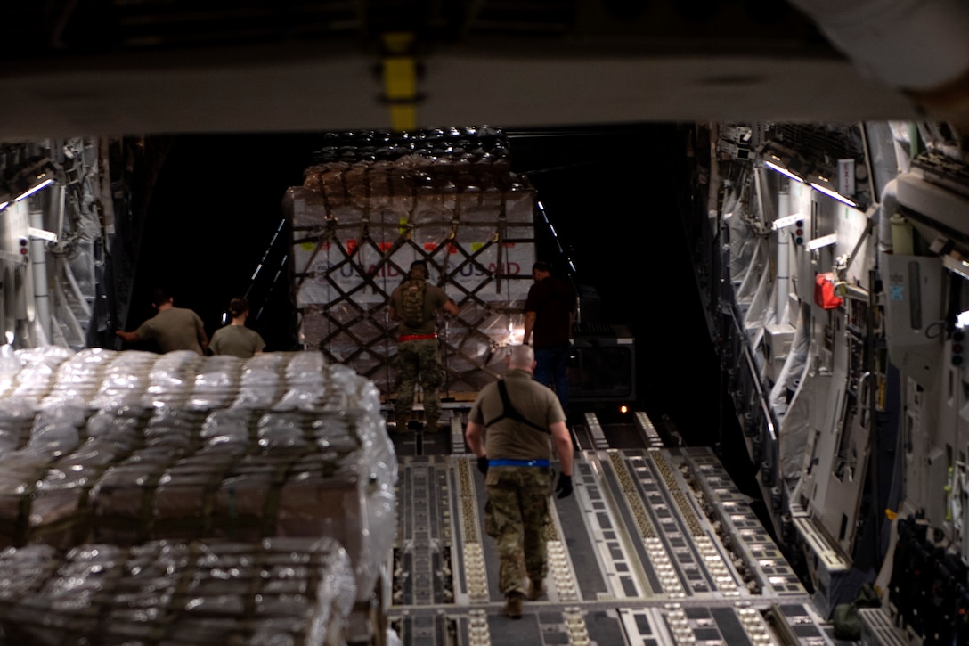 Airmen load pallets onto an aircraft.