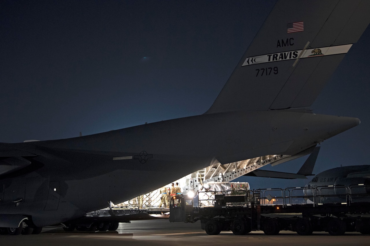 Airmen load pallets onto an aircraft.