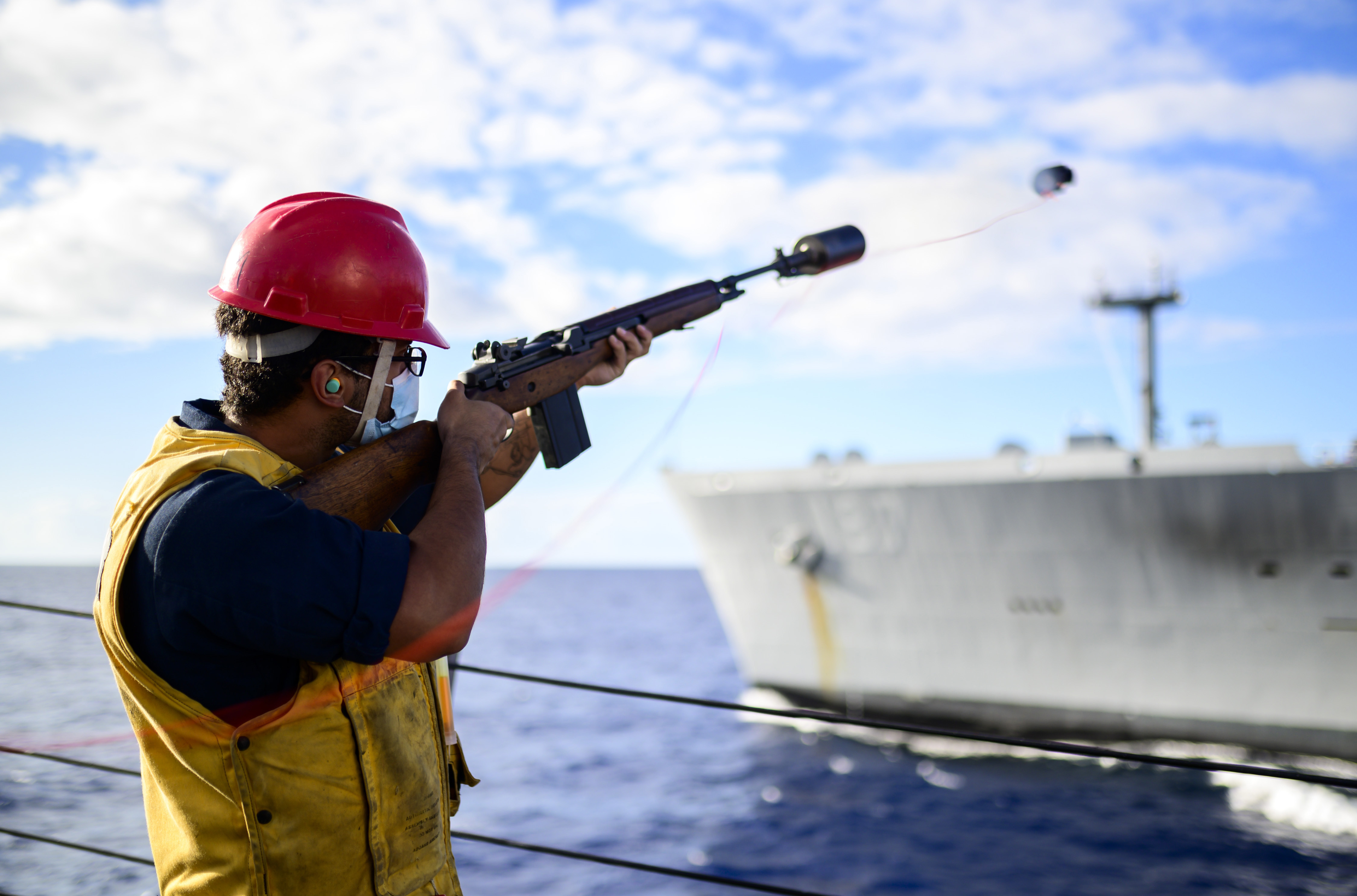 Gunner’s Mate Seaman Apprentice Christopher Delvalle, from Philadelphia, fires a shot line as USS Chung-Hoon (DDG 93) conducts a replenishment-at-sea with USNS Henry J. Kaiser (T-AO 187)
