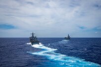 The amphibious dock landing ship USS Germantown (LSD 42), left, and the amphibious assault ship USS America (LHA 6) maneuver out of a tactical formation.