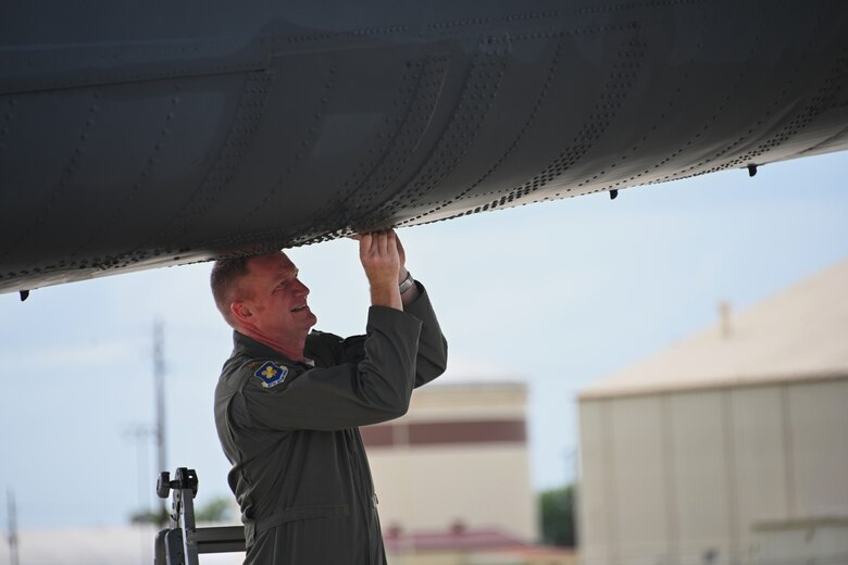 An Airman closes the latch on a B-52 storage compartment door.