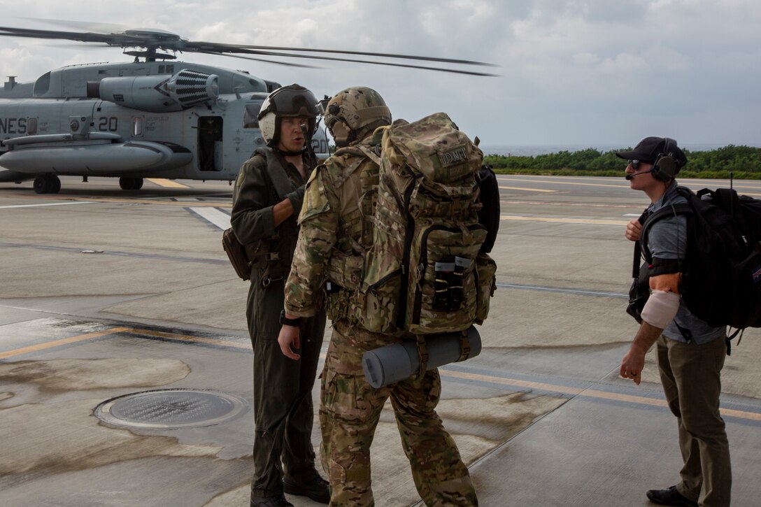 A U.S. Airman with Special Operations Forces Medical Element, 18th Wing, and a Marine with Marine Corps Force Recon Company, 3rd Reconnaissance Battalion, talk to the crew chief of a CH-53E Super Stallion with Marine Heavy Helicopter Squadron 361 (HMH-361) before boarding at Ie Shima, Okinawa, Japan, Oct. 8, 2020. The Airmen conducted various operations on casualties until transported to the U.S. Naval Hospital Okinawa, in support of exercise Noble Fury 21. (U.S. Marine Corps photo by Cpl. Ethan M. LeBlanc)