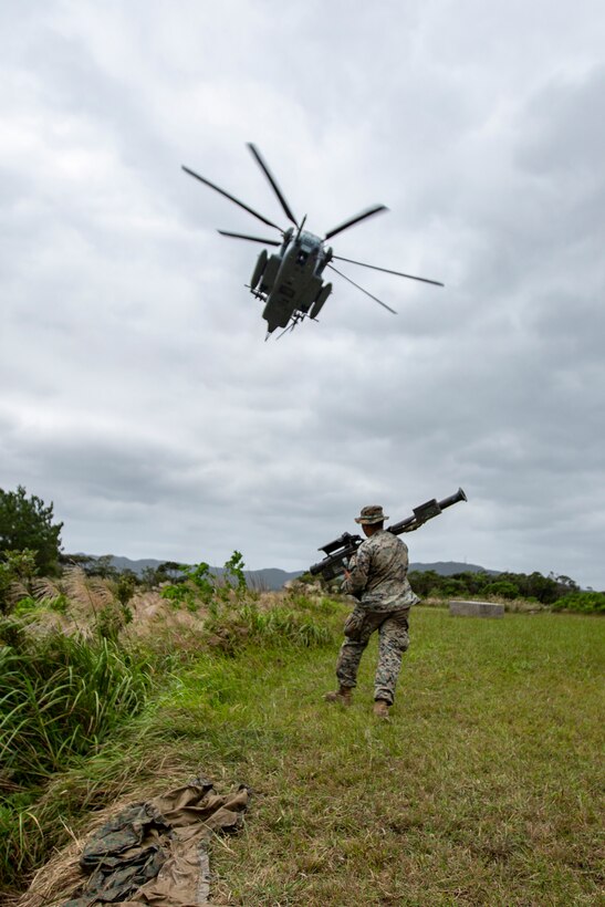 A U.S. Marine Corps Low Altitude Air Defense (LAAD) gunner with 3rd LAAD Battalion runs for cover as a CH-53E Super Stallion with Marine Heavy Helicopter Squadron 361 (HMH-361) passes overhead during a combined Ground Threat Reaction (GTR) training event at the northern training area, Okinawa, Japan, Oct. 23, 2020. 3rd LAAD and HMH-361 conducted the training event to improve their skills and proficiency with both aerial maneuvers and the THT weapon system. (U.S. Marine Corps photo by Cpl. Ethan M. LeBlanc)