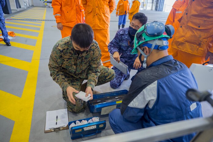 U.S. Marine Corps Sgt. Meanong Lor, an aircraft electrical systems technician with Marine Aerial Refueler Transport Squadron 152 and Japan Maritime Self-Defense Force personnel with Maintenance and Supply Squadron 31 inspect tools during Exercise Keen Sword 2021 at Marine Corps Air Station Iwakuni, Japan, Nov. 2, 2020. Keen Sword is a series of joint/bilateral training exercises designed to increase combat readiness and interoperability of Japan Self-Defense Force and U.S. forces. (U.S. Marine Corps photo by Lance Cpl. Tyler Harmon)