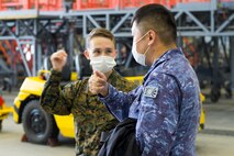 U.S. Marine Corps Cpl. Adam Gresham with Marine Aerial Refueler Transport Squadron 152 speaks with Japan Maritime Self-Defense Force personnel during Exercise Keen Sword 2021 at Marine Corps Air Station Iwakuni, Japan, Nov. 2, 2020. Keen Sword is a series of joint/bilateral training exercises designed to increase combat readiness and interoperability of Japan Self-Defense Force and U.S. forces. (U.S. Marine Corps photo by Lance Cpl. Tyler Harmon)