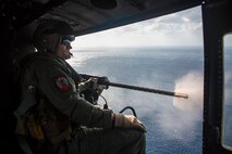A U.S. Marine Corps UH-1Y Venom helicopter crew chief, with Marine Light Attack Helicopter Squadron 469 (HMLA-469), monitors a fellow crew chief firing a GAU-21 machine gun during a live-fire training event in Okinawa, Japan, Nov. 3, 2020. HMLA-469 conducted the training to simulate fighting in a forward operating environment to enhance the squadron’s combat readiness. (U.S. Marine Corps photo by Cpl. Ethan M. LeBlanc)