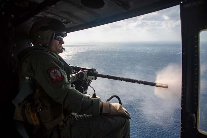 A U.S. Marine Corps UH-1Y Venom helicopter crew chief, with Marine Light Attack Helicopter Squadron 469 (HMLA-469), monitors a fellow crew chief firing a GAU-21 machine gun during a live-fire training event in Okinawa, Japan, Nov. 3, 2020. HMLA-469 conducted the training to simulate fighting in a forward operating environment to enhance the squadron’s combat readiness. (U.S. Marine Corps photo by Cpl. Ethan M. LeBlanc)