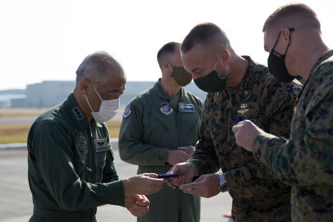 U.S. Marine Corps Col. Frederick Lewis, Marine Corps Air Station (MCAS) Iwakuni commanding officer, receives a small gift from Lt. Gen. Hiroshi Kaminotani, Japan Air Defense Command Vice Commander, aboard Marine Corps Air Station Iwakuni, Japan, Nov. 17, 2020. The visit enabled U.S. and Japanese military leaders to continue to build upon strong relationship and maintain mutual understanding of strategically placed aviation capabilities in the Pacific. (U.S. Marine Corps photo by Lance Cpl. Bryant Rodriguez)