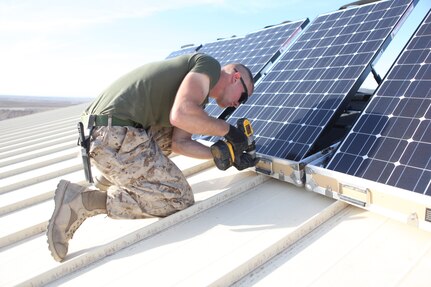U.S. Marine Corps Cpl. Robert G. Sutton, left, and Cpl. Moses E. Perez, field wireman with Combat Logistics Regiment 15 install new solar panels on Combat Outpost Shukvani, Helmand province, Afghanistan, Nov. 19, 2012.