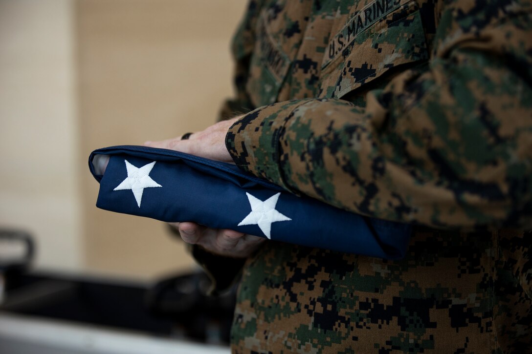 U.S. Marine Corps Sergeant Major Gabriel E. Macias, Battalion Sergeant Major, Headquarters Battalion, receives "Old Glory" from First Sergeant James E. Gorczynski, Company First Srgeant, Headquarters Company, at the National Museum of the Marine Corps in Triangle, Va., Nov. 25, 2020. Sergeant Maj. Macias retired after 25 honorable and faithful years to the U.S. Marine Corps. (U.S. Marine Corps photo by Cpl. Webster Rison)