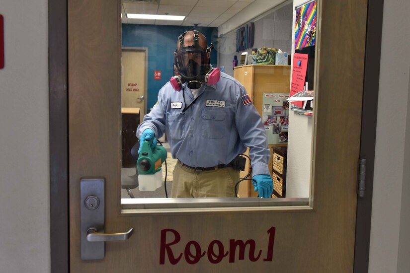 A man disinfects a classroom.