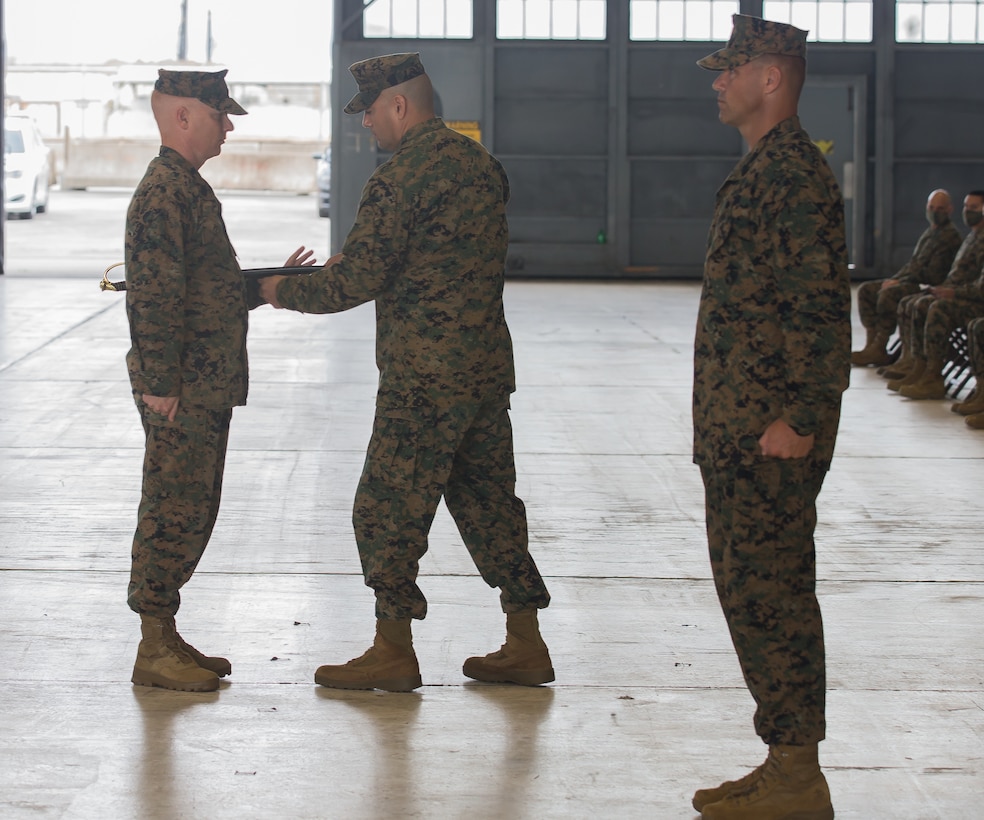 U.S. Marine Corps Sgt. Maj. James I. Petty, left, receives the non-commissioned officer sword from Lt. Col. Julian Flores