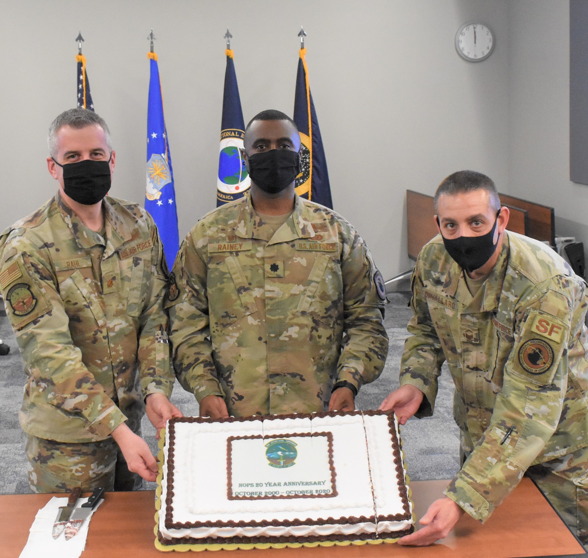 From left, Maj. David Rahl, National Reconnaissance Office Operations Squadron director of operations, Lt. Col. Roland Rainey, NOPS commander and Senior Master Sgt. Joseph Cavallaro, NOPS superintendent, hold a cake recognizing the NOPS’s 20th anniversary Oct. 30, 2020, at Schriever Air Force Base, Colorado. The NOPS employs global resources to provide critical connectivity and telemetry, tracking and command data while serving as the single NRO interface to the Air Force Satellite Control Network. (U.S. Space Force courtesy photo)