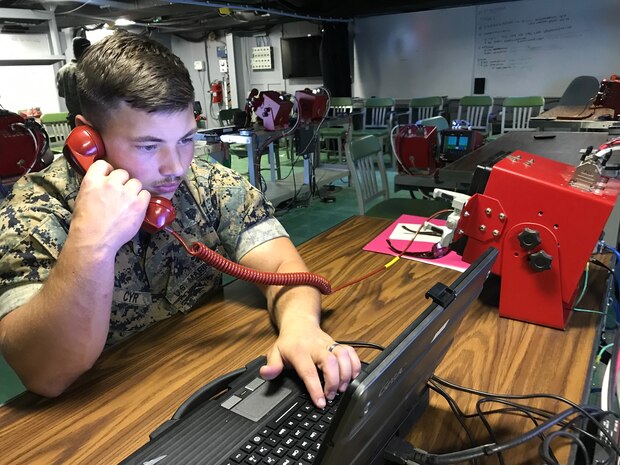 A U.S. Marine performs a functions check on the communications equipment inside the Landing Force Operations Center, Oct. 29.