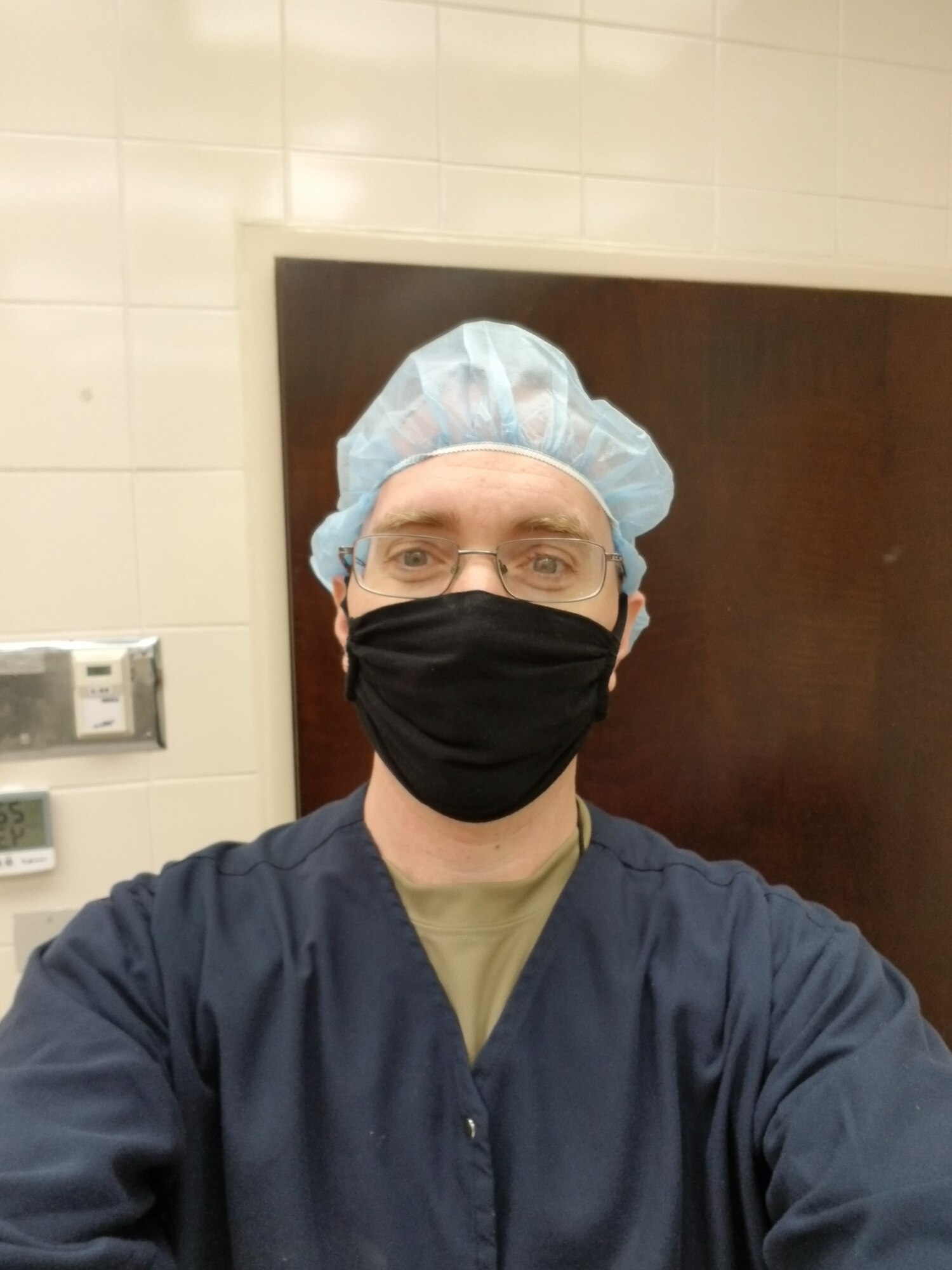 Man in scrubs with mask.