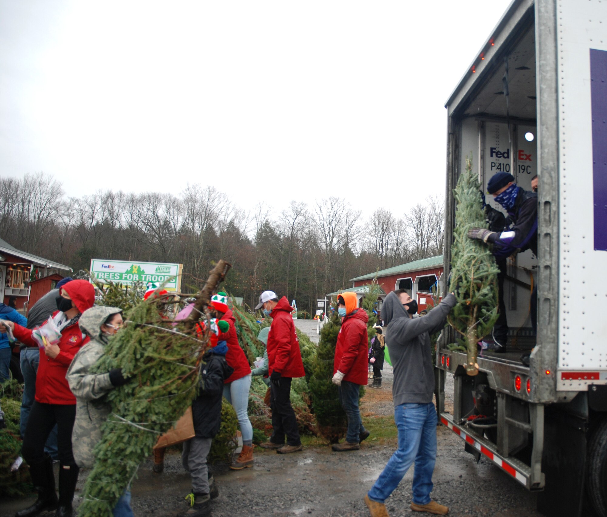 Volunteers pass a tree up to FedEx driver Don Pelletier during the Trees for Troops loadout on Nov. 30, 2020, at Ellms Tree Farm in Ballston Spa, N.Y. More than 20 volunteers from the New York Army and Air National Guard joined with Capital District area veterans to help load about 125 Christmas trees being donated and sent to military bases around the country to support troops and military families this holiday season.